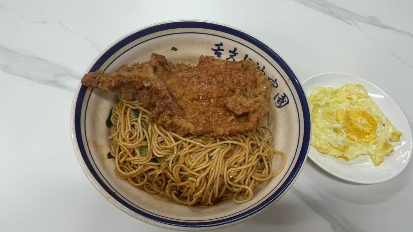 Fried pork chop noodles with a fried egg